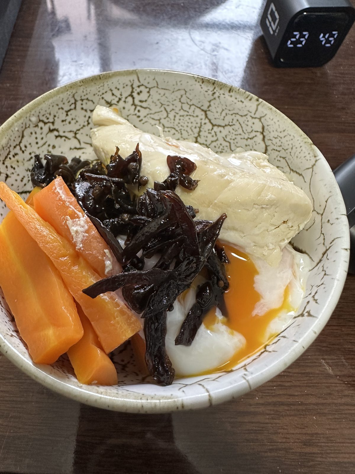3食目（15:00）。 ゆでささみ・温泉卵（黄身が流れている）・しそきくらげ・ゆでにんじんを、白米の上に載せた1皿。自宅の定番構成に戻った日の代表的な1食。