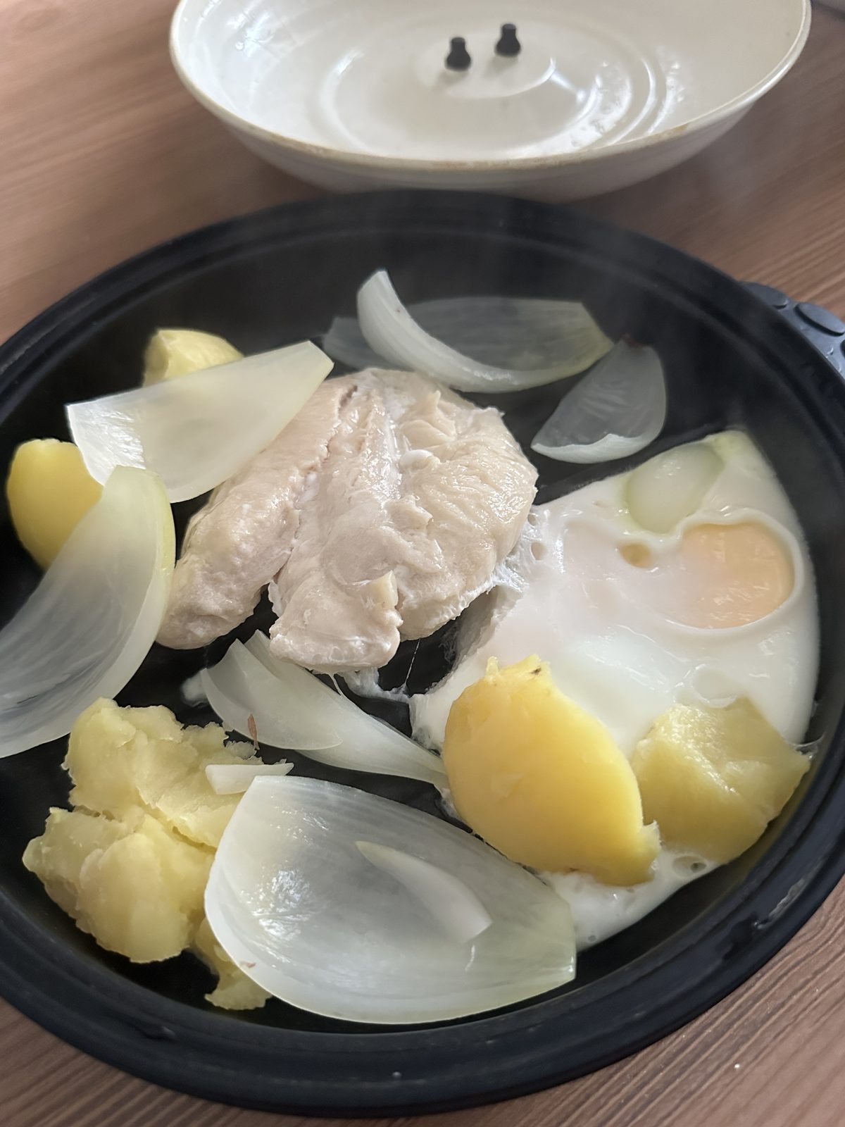 🧅 玉ねぎテスト1日目の1食（16:02）。 レンジ調理容器に、ゆでささみ・蒸したじゃがいも・温泉卵・くし切りの玉ねぎを入れて加熱した1皿。玉ねぎは透き通るまで火が通っている（生ではない）。復帰テストの初日を写真で残せた。