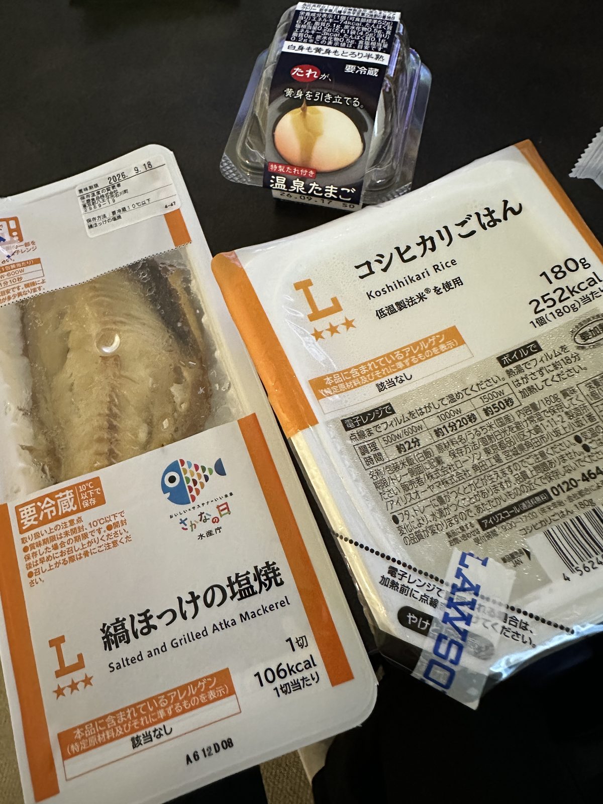 — 🆕 朝食の現物（開封前）。ローソンで購入。 コシヒカリごはん 180g・252kcal ／ 縞ほっけの塩焼 1切・106kcal ／ 温泉たまご（たれ付き）。